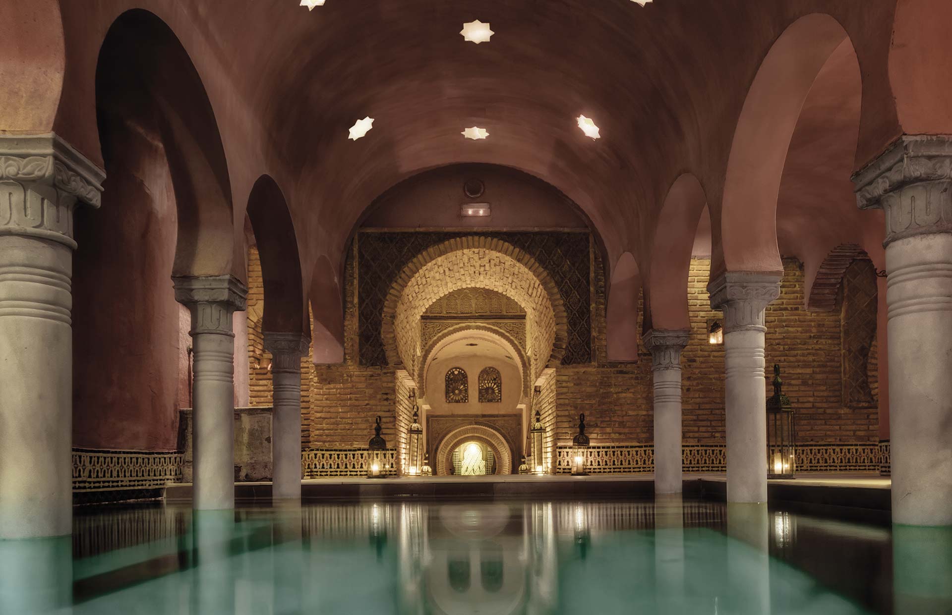 Interior de Hammam Al Ándalus en Granada, con arcos, columnas y estanque